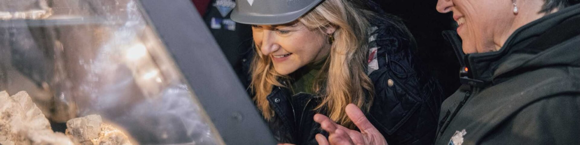 Grossherzogin Stephanie von Luxemburg laechelt im grauen Schutzhelm, waehrend sie Gesteinsstuecke in einer Vitrine des Schiefermuseums in Haut-Martelange betrachtet - Photo: Maison du Grand-Duc