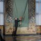 Die Enthüllung von König Frederik X.' erstem Porträt: Ein Mann im dunklen Anzug zieht an der Schnur der in grüne Seide gehüllten Leinwand im Rittersaal von Schloss Frederiksborg — Photo: Kongehuset