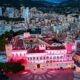 Aerial view of the Prince's Palace of Monaco glowing pink and red at dusk above the old town - Photo: Michaël Alesi / Palais princier