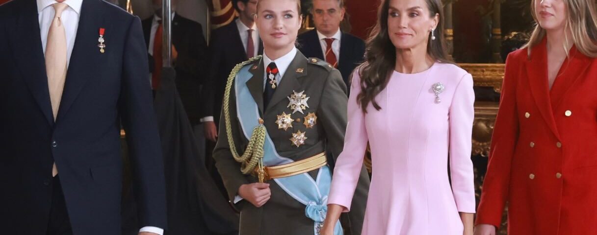 König Felipe VI., Königin Letizia, Prinzessin Leonor und Infantin Sofia schreiten am Dia de la Fiesta Nacional durch einen prunkvollen Saal des Königspalasts von Madrid, die Königin in zartrosa, die Infantin in leuchtend Rot - Photo: @casareal.es