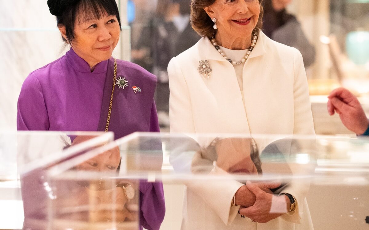 Koenigin Silvia in Elfenbein-Weiss mit Jane Ittogi Shanmugaratnam in Lila vor einer Keramikvitrine im Nationalmuseum in Stockholm - Foto: Sara Friberg/Kungl. Hovstaterna