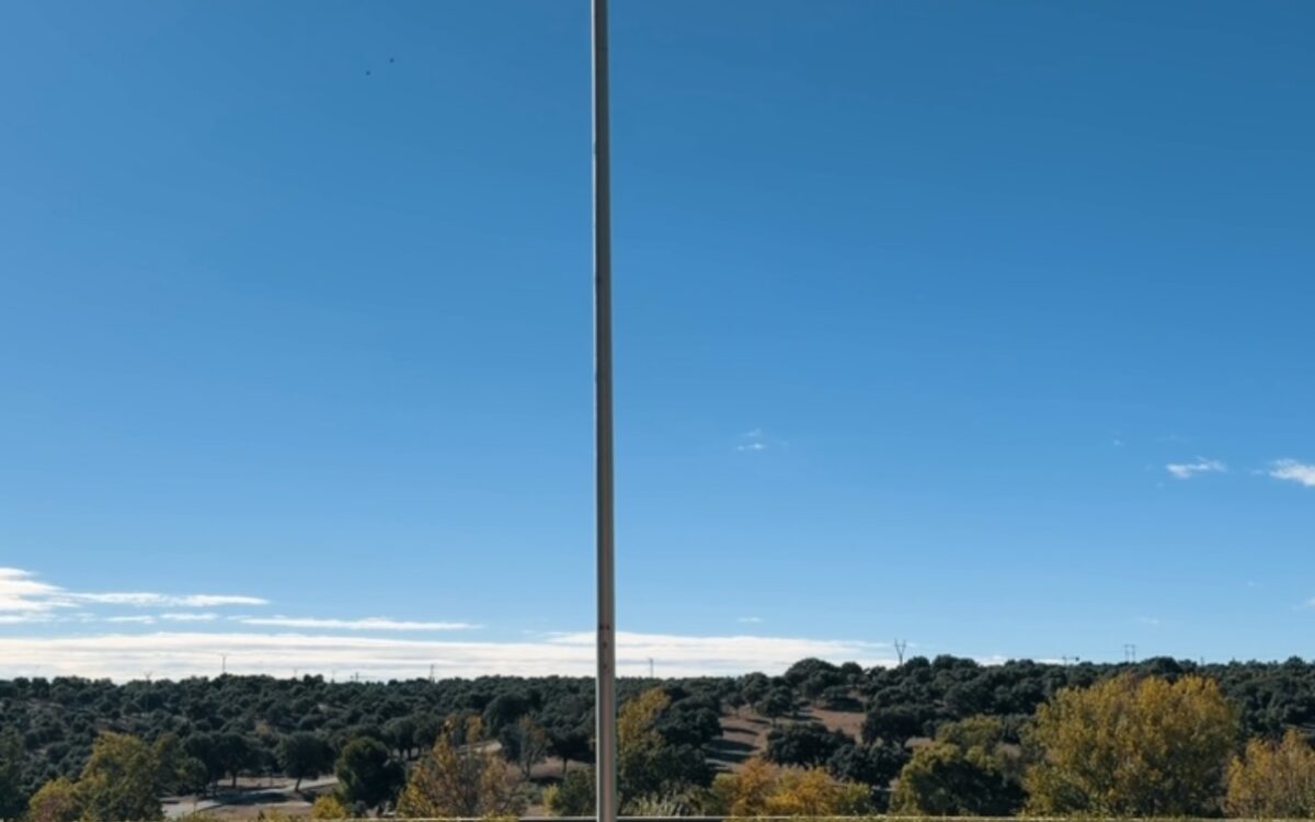Die spanische Nationalflagge weht an einem Fahnenmast über den gepflegten Gärten des Palacio de la Zarzuela bei strahlend blauem Himmel — Photo: @casareal.es