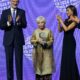 König Felipe VI. und Königin Letizia applaudieren, während Isabel Allende die Premio-Planeta-Trophäe auf der Bühne der Fira de Barcelona hält, sie in bestickter Tunika und die Königin in schwarzem Abendkleid - Photo: @casareal.es