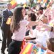 Königin Letizia in rosa Bluse begrüßt mit offenen Armen eine jubelnde Menge mit spanischen Fahnen in Melilla, König Felipe VI. lächelt hinter ihr - Photo: @casareal.es