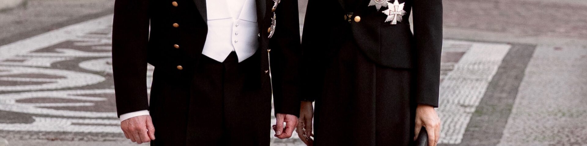 König Frederik X. und Königin Mary in festlicher Uniform mit glitzernden Orden vor den goldenen Türen des Palasts Christian VII. auf Schloss Amalienborg — Photo: Kongehuset