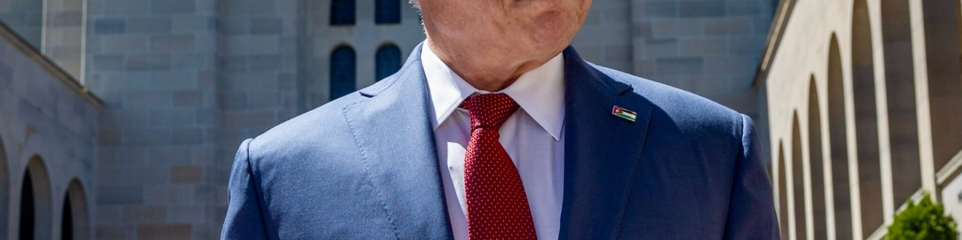 König Abdullah II. von Jordanien im dunkelblauen Anzug mit roter Krawatte und Jordanien-Anstecker im Sonnenschein in Canberra beim Staatsbesuch in Australien - Photo: @rhcjo