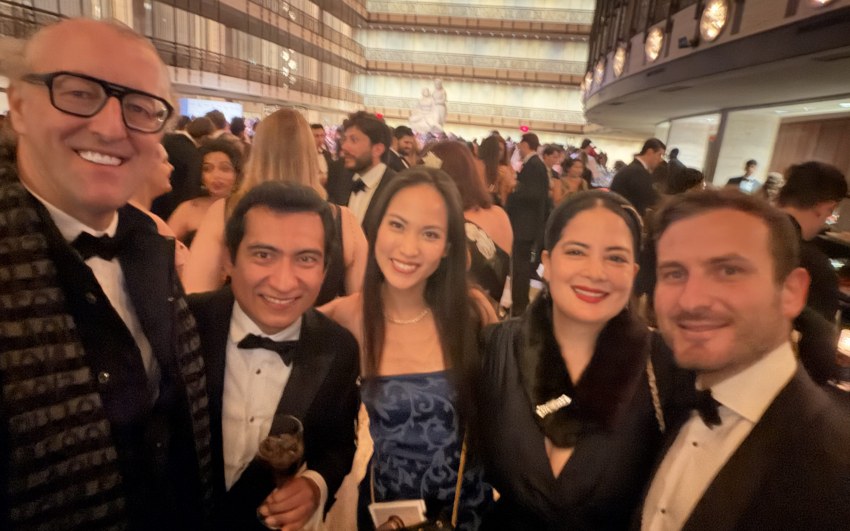 Festlich gekleidete junge Gaeste des Balanchine Ball laecheln in der Lobby eines New Yorker Theaters waehrend der Ballnacht.