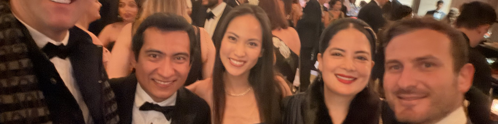 Festlich gekleidete junge Gaeste des Balanchine Ball laecheln in der Lobby eines New Yorker Theaters waehrend der Ballnacht.