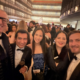Festlich gekleidete junge Gaeste des Balanchine Ball laecheln in der Lobby eines New Yorker Theaters waehrend der Ballnacht.