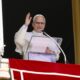 Papst Leo XIV lächelt und winkt vom Fenster des Apostolischen Palastes, Mikrofon und rotes Papstbanner im Bild - Photo: @pontifex