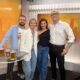 Prinz Mario-Max zu Schaumburg-Lippe im weißen Hemd mit Tania Rubis und Gästen im RTVI-Studio in Manhattan vor orangefarbenen Bildschirmen