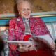 Queen Margrethe of Denmark smiling while browsing magazines at Fredensborg Palace — Photo: Kongehuset