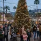 Weihnachtszauber in den Universal Studios Hollywood: ein riesiger Weihnachtsbaum, fallender Schnee und festlich beleuchteter Platz in der Abenddämmerung.
