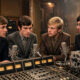Vier junge Musiker mit Instrumenten der sechziger Jahre in einem warm beleuchteten Tonstudio - Originalszene zum Beatles-Filmereignis von Sam Mendes in vier Filmen fuer April 2028.
