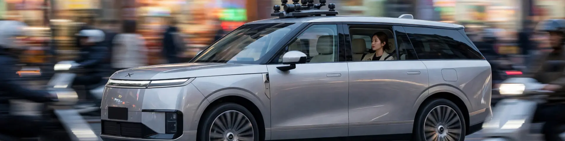 Silbernes XPeng Robotaxi fährt durch eine chinesische Großstadt bei Dämmerung